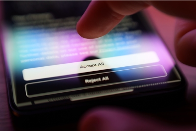Doigt appuyant sur un bouton 'Accepter tout' sur un écran de smartphone, illustrant le consentement aux cookies et à la gestion des données personnelles.